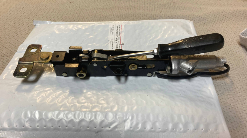 bow lock assembly with a screwdriver lifting the open locking pawl